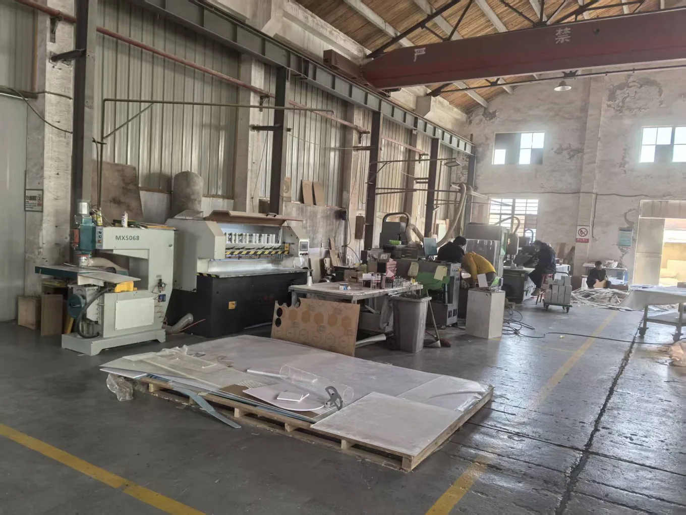 Key-Joint workshop hall in Shanghai with routing equipment, work benches and large formed parts, with operatives working at several stations