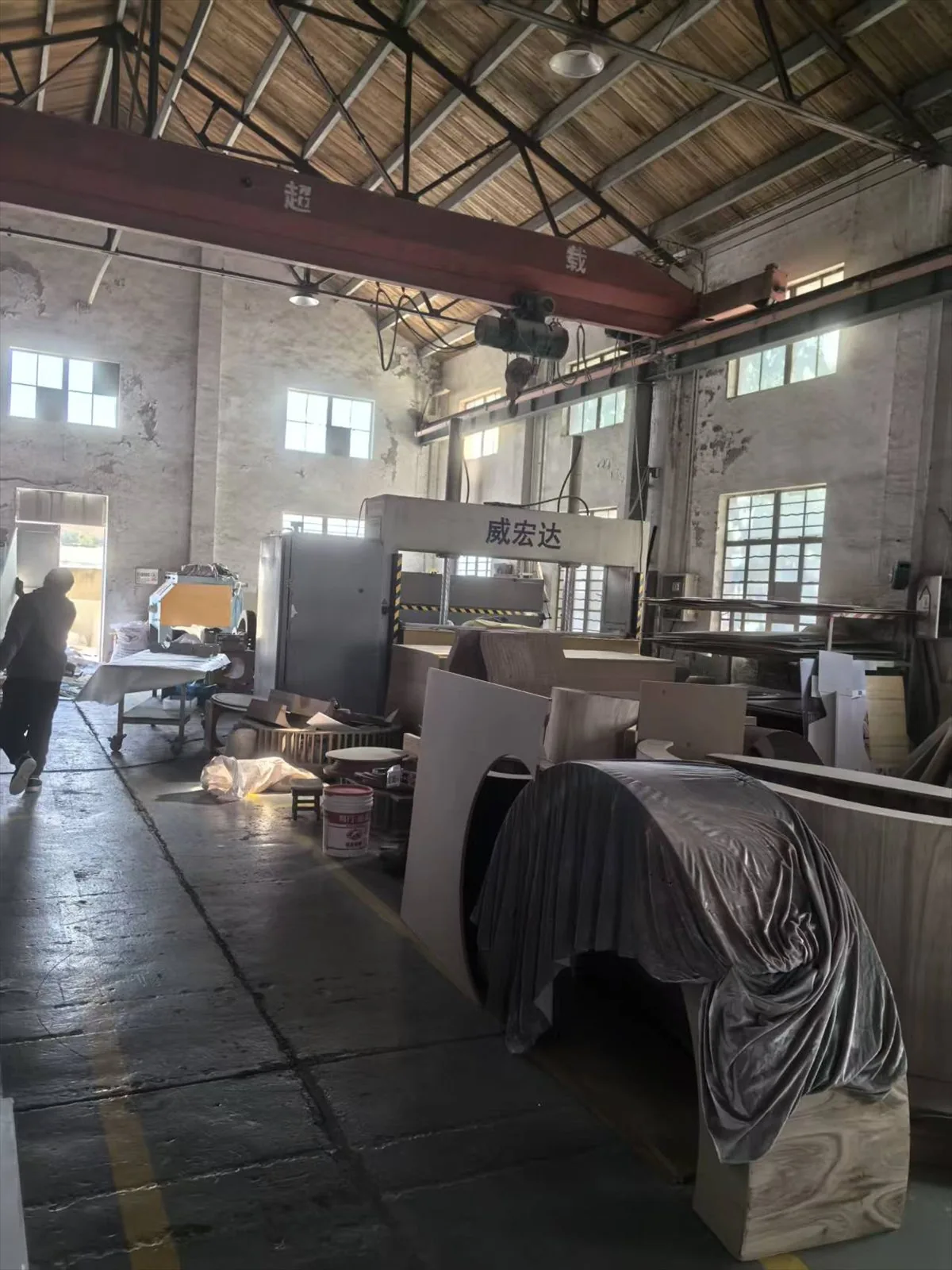 Formed display shells and pattern blocks in the finishing bay of the Shanghai workshop, with an overhead gantry crane