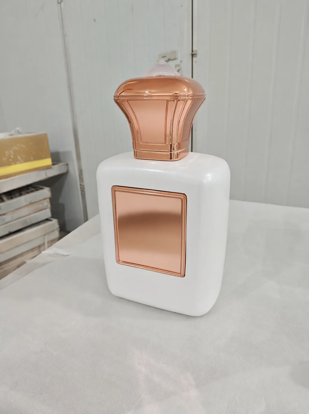 0.4 m white factice perfume bottle with a crackle lacquer body, polished copper-tone cap and a blank copper plaque